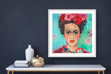 Load image into Gallery viewer, A beautiful and colourful print of Frida Kahlo with red and pink flowers in Frida&#39;s hair against a turquoise and aqua background. Framed in white against a dark grey wall.
