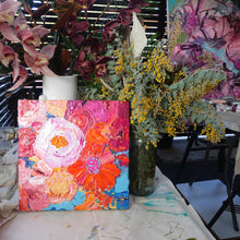 Load image into Gallery viewer, Petal is an original painting of a mass of pale pink, hot pink, orange and soft yellow flowers on a light blue background. Acrylic on canvas, 39cm x 39cm. Shown in the artist&#39;s studio, next to vases of flowers.
