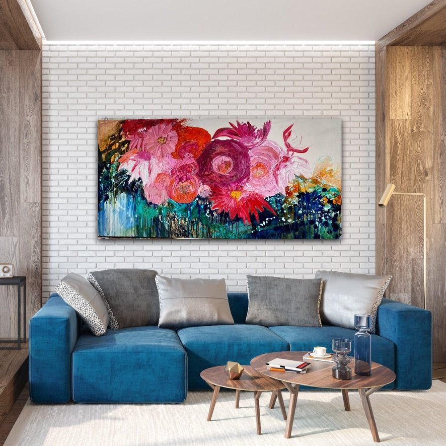 Midnight in the Garden is a large, impressionist style original painting of a mass of hot pink, pale pink and orange blooms on a turquoise, aqua and white background, oil on canvas, light Tasmanian Oak box frame152cm x 76cm. Shown in situ in a living room against a white brick wall.