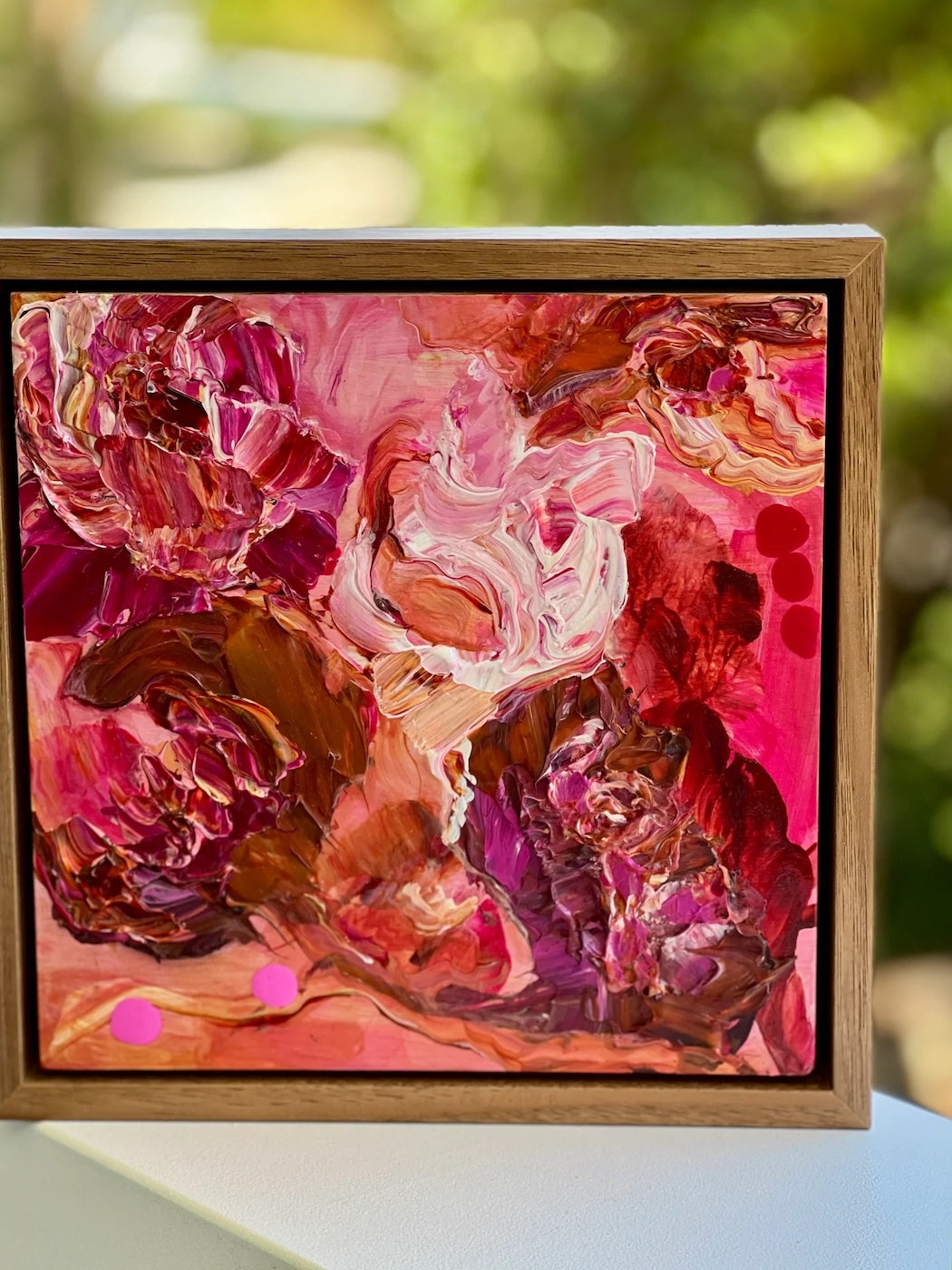 Pink blooms in all the shades of pink. Shown on a verandah railing.