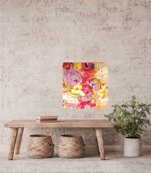 A pretty mass of yellow, pale pink and hot pink coloured blooms, with some leaves in a lovely shade of green, against a blush pink wall.