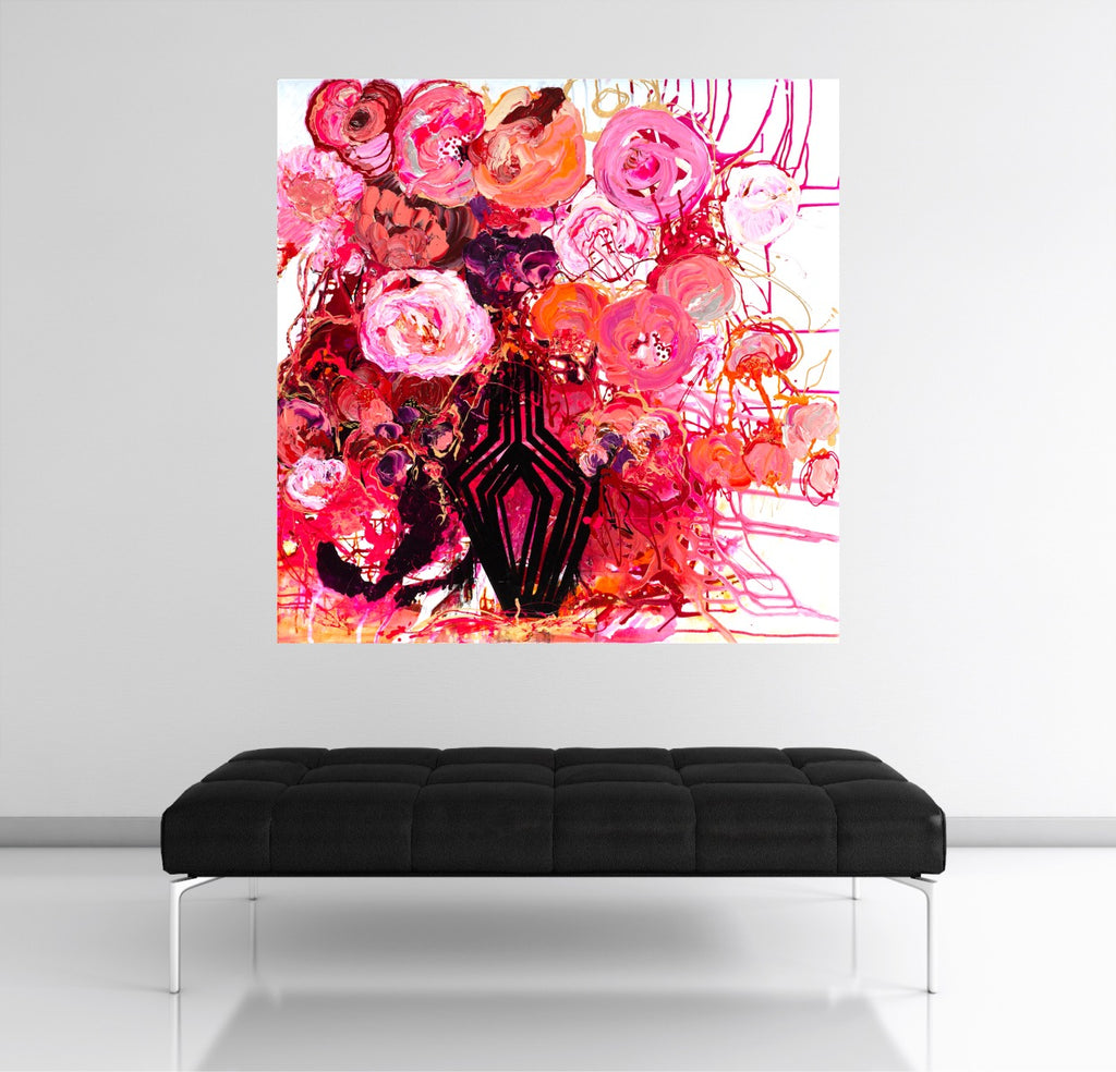 Buds & Blooms is a vibrant mass of red and pink blooms in a black vase against a white wall.