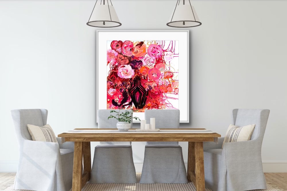 Buds & Blooms is a vibrant mass of red and pink blooms in a black vase in a white frame.