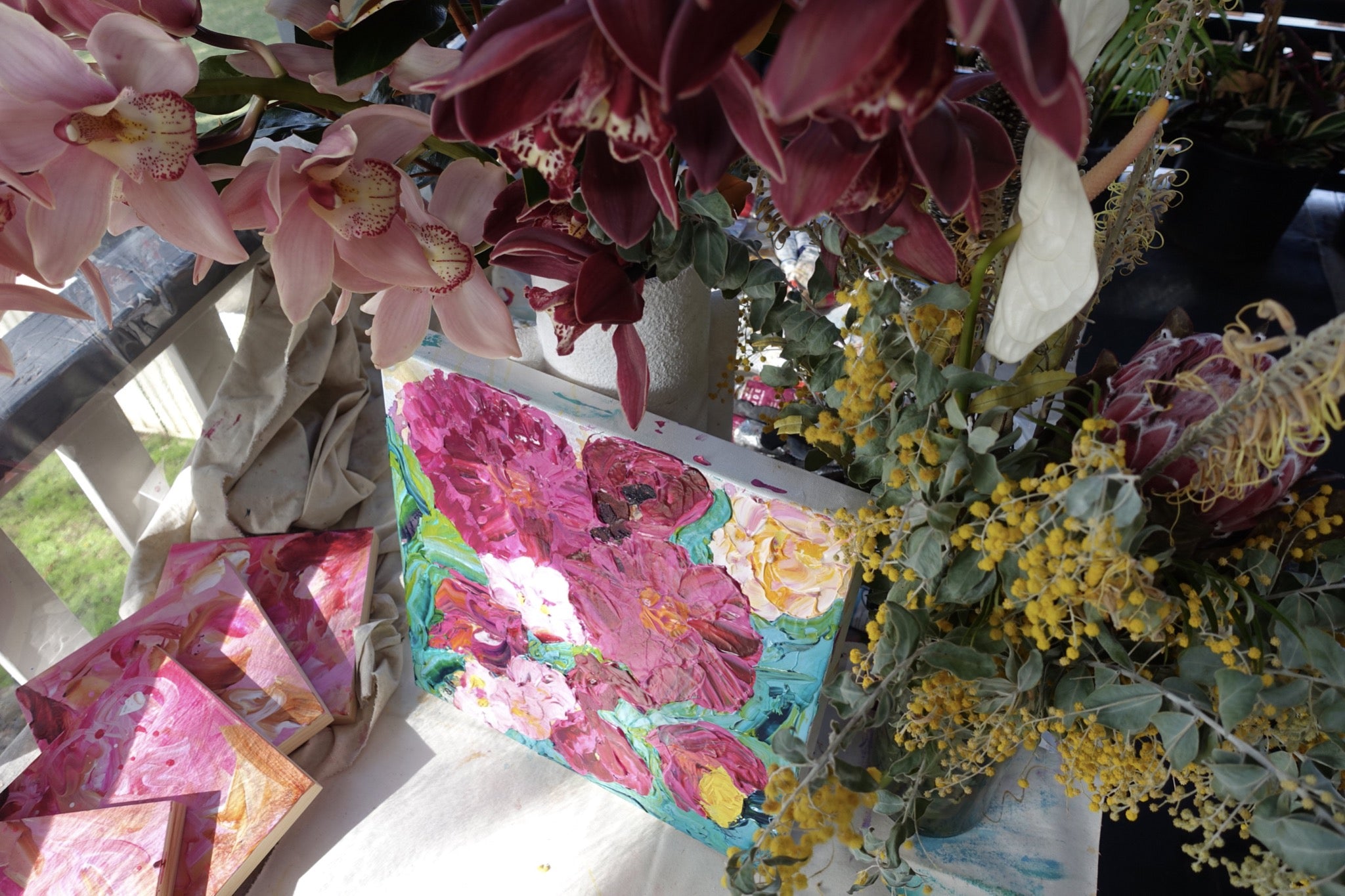 Peony Coast is an original painting of a bunch of hot pink and pale pink blooms on a turquoise background by artist Kerry Bruce, acrylic on canvas, 39cm x 39cm.