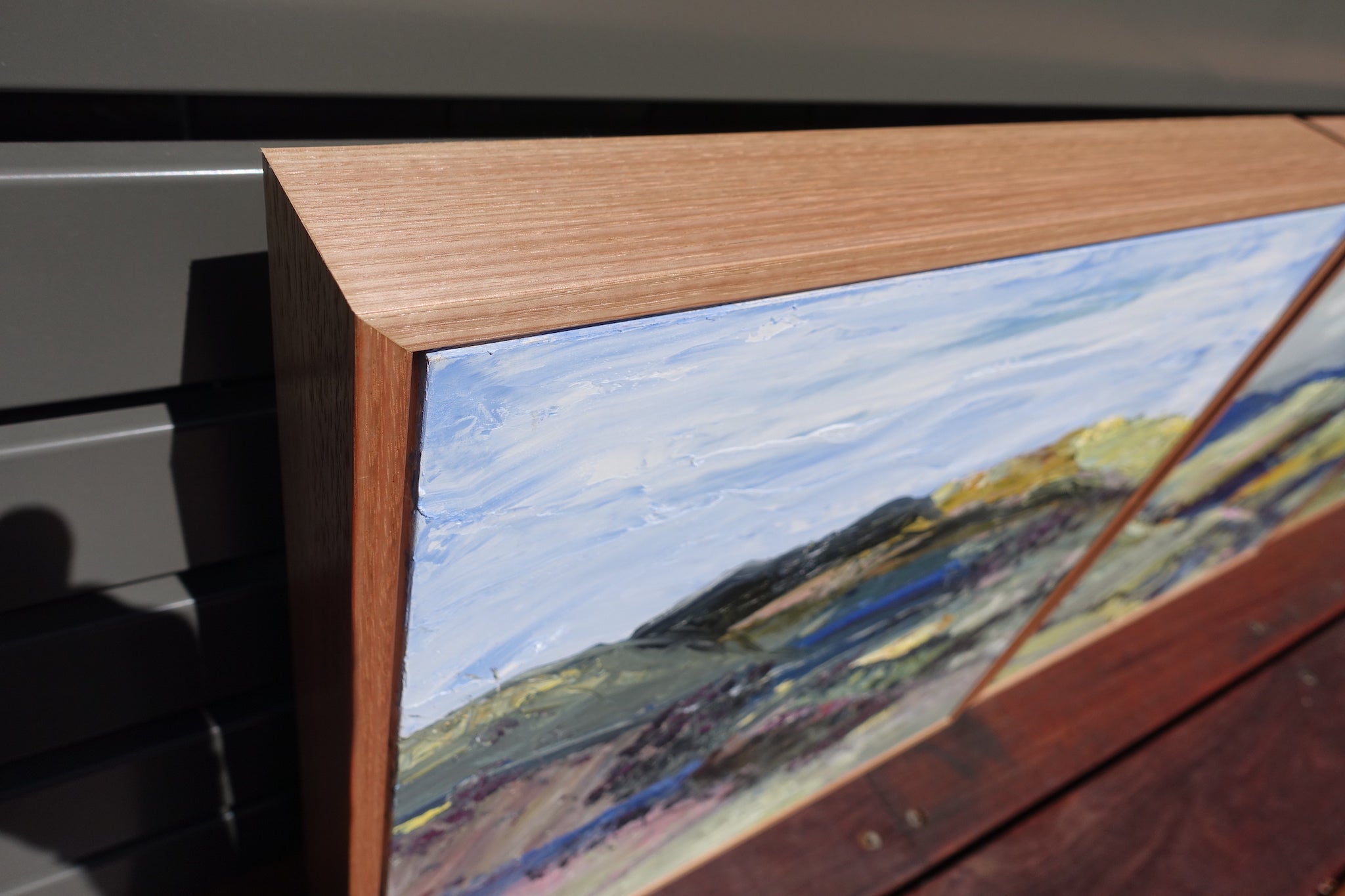 Abstract landscape with the countryside painted in yellow, pink, green and blue. Close-up of frame.