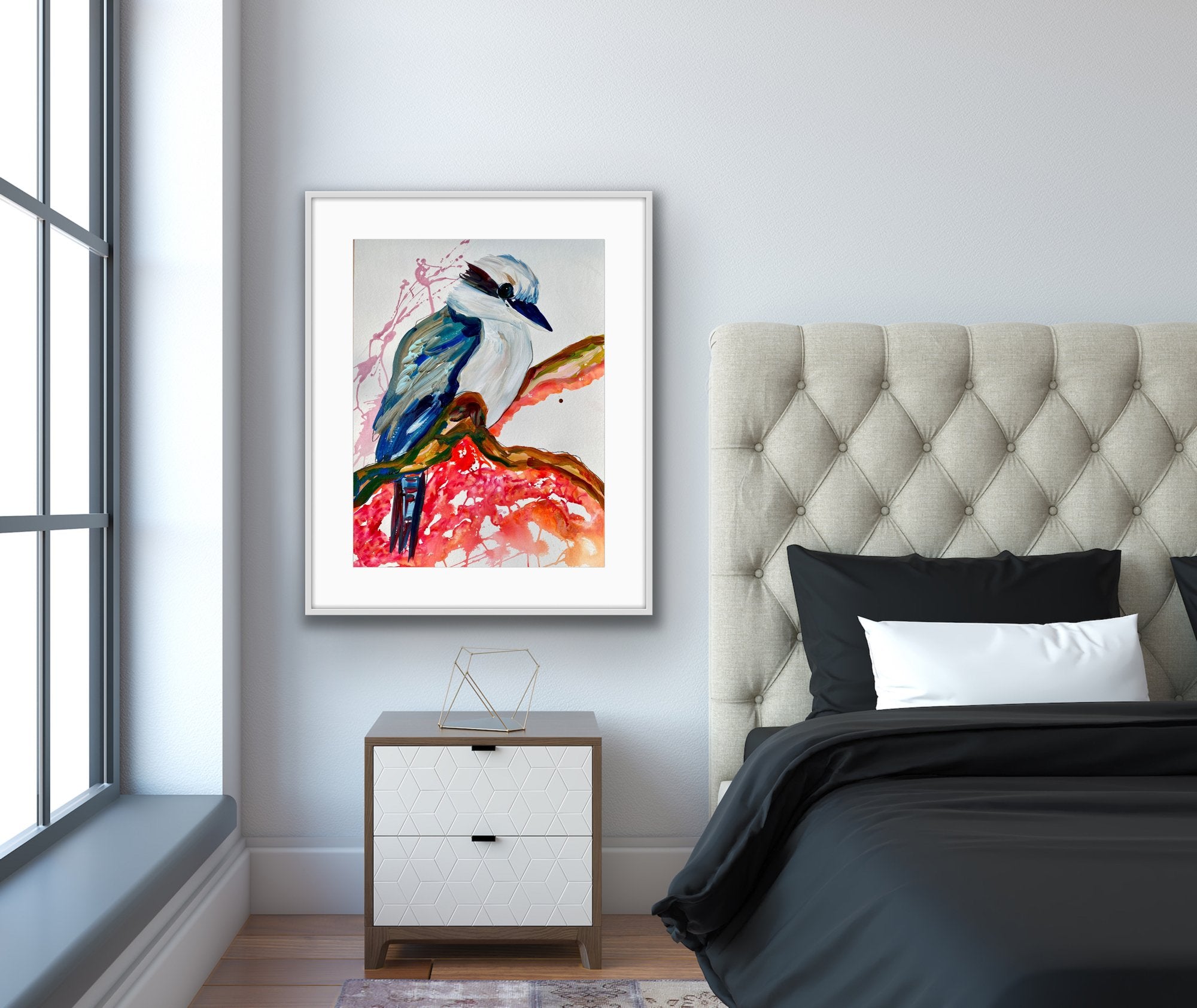 Kelsey Kookaburra is an original painting of a kookaburra, acrylic on 500gsm archival art paper, framed in white timber. Shown in situ in a bedroom against a pale grey wall.
