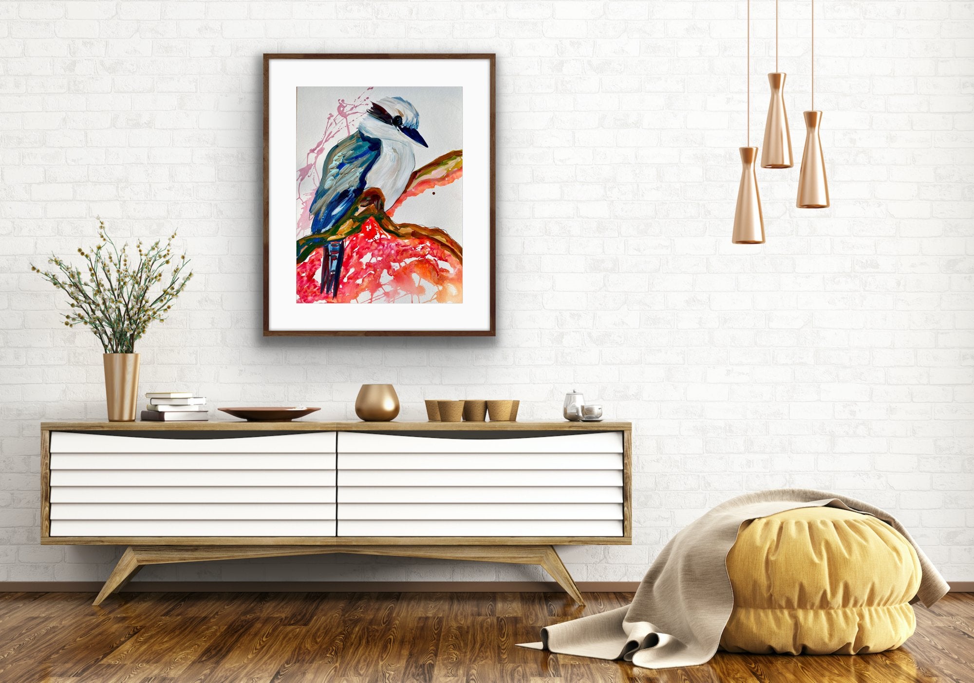Kelsey Kookaburra is an original painting of a kookaburra, acrylic on 500gsm archival art paper, framed in oak. Shown in situ against a white brick wall above a white and timber sideboard.