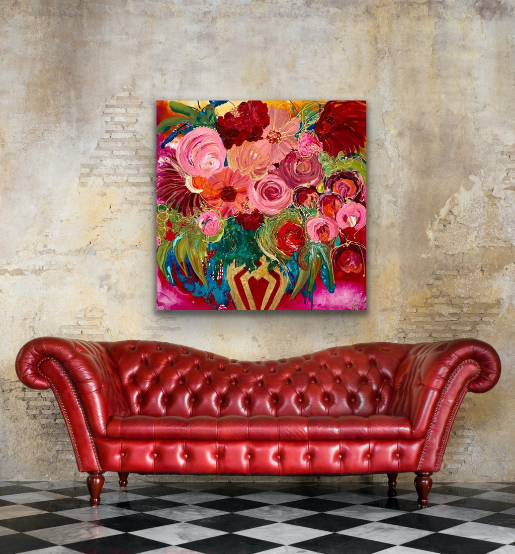 Petal Power is an original painting of a stunning mass of flowers in a gold and red vase against a hot pink background. 94cm x 94cm, acrylic on linen, framed in Tassie Oak box frame. Shown in situ on an industrial wall above a red leather studded sofa.