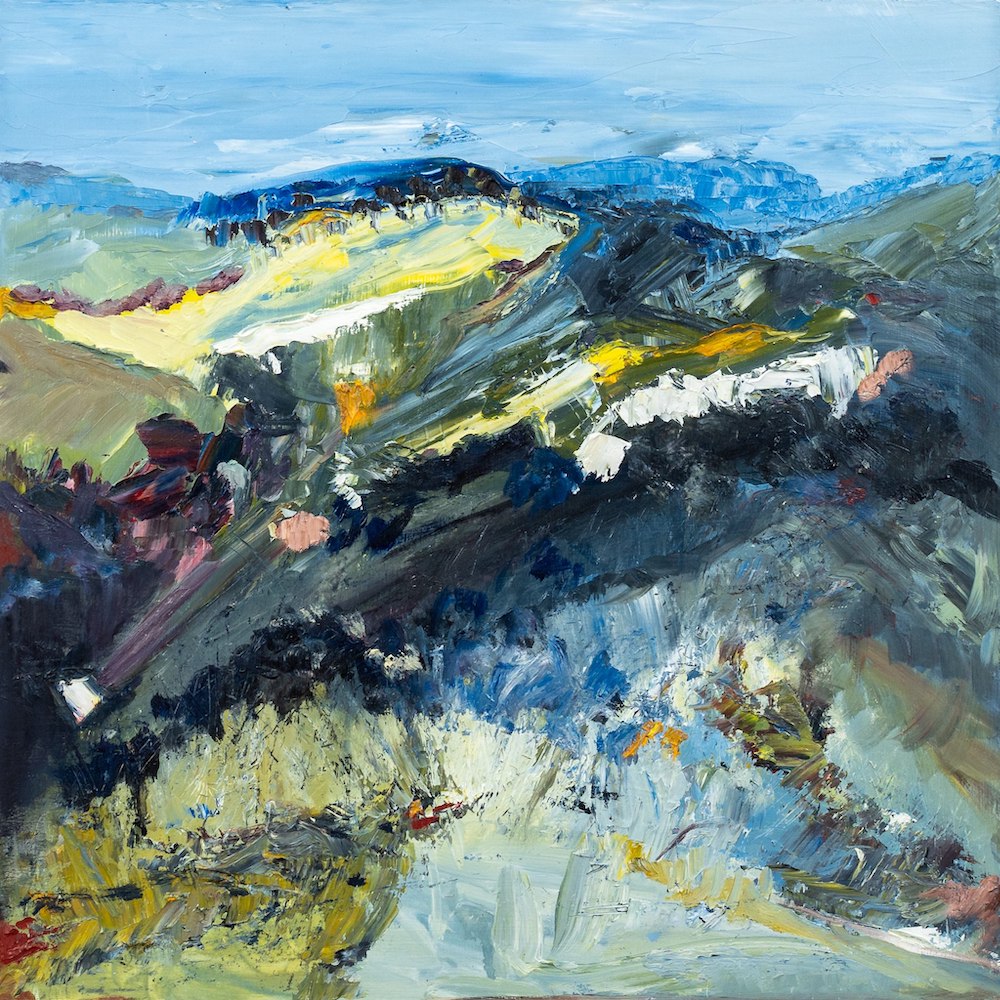 Abstract landscape with flashes of yellow in the countryside and blue mountains and blue sky.