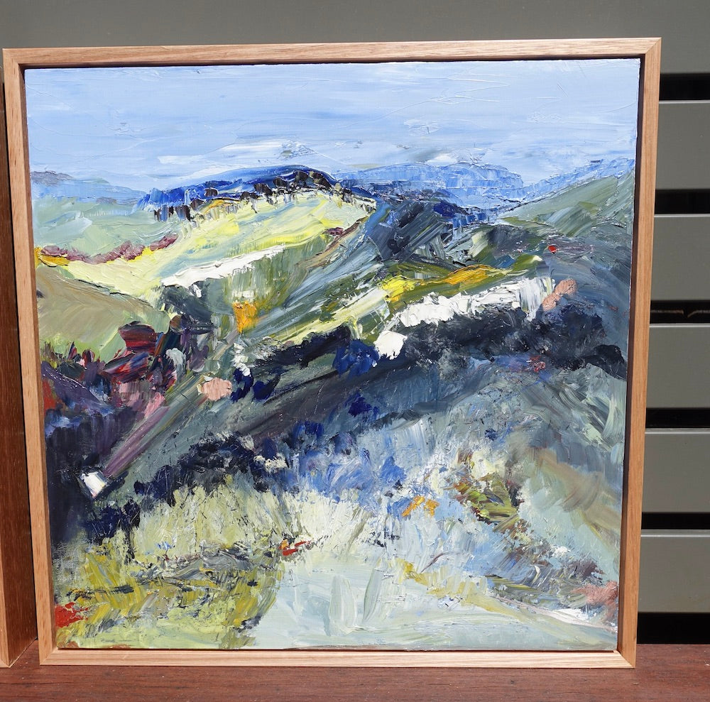 Abstract landscape with flashes of yellow in the countryside and blue mountains and blue sky. Framed view.