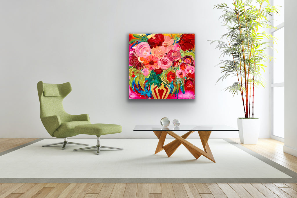 Petal Power is an original painting of a stunning mass of flowers in a gold and red vase against a hot pink background. 94cm x 94cm, acrylic on linen, framed in Tassie Oak box frame. Shown in situ on a pale grey wall behind a pale green armchair and footrest.