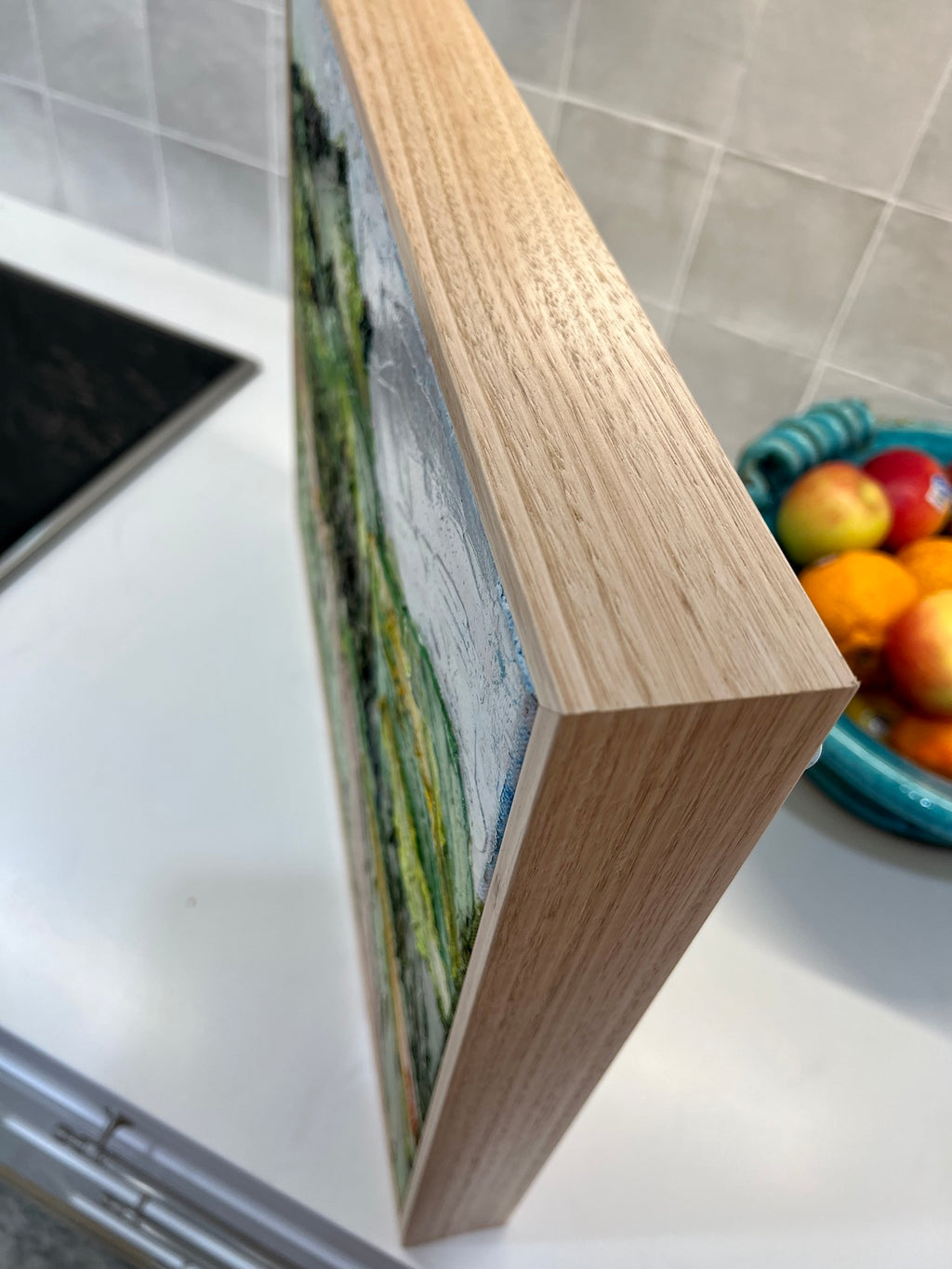 Abstract landscape of rolling green and yellow hills and a winding pink road. Close-up view of frame.