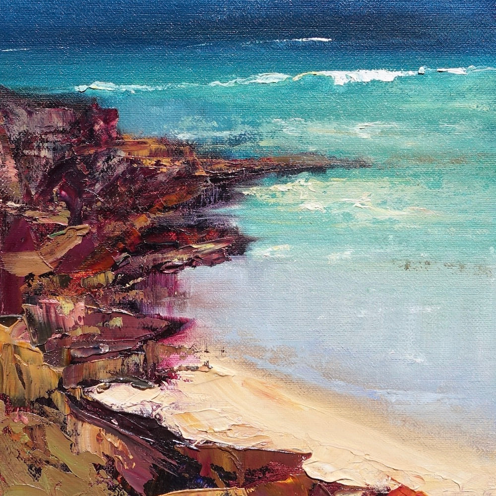 Abstract beach scene with buttercup coloured sand, turquoise ocean and reddish brown rocks in the corner of the beach. Square view.