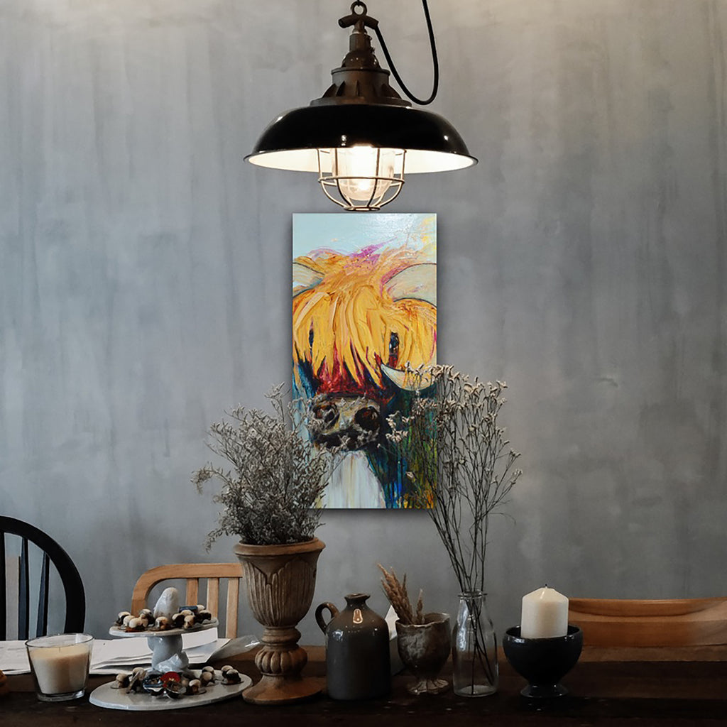 Blondie is a painting of a gorgeous bovine with long blonde hair, shown against a grey wall.