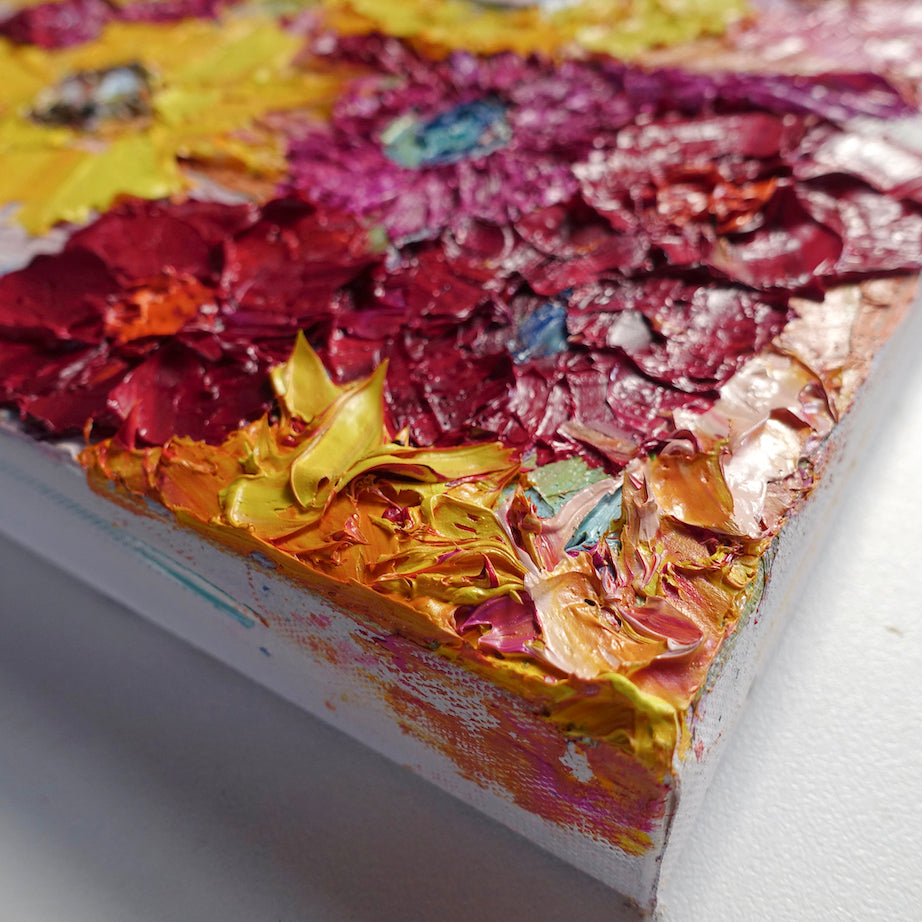 Close up view of a painting of a pretty mass of blooms in shades of yellow, red, pale and deep pink.